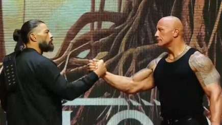 Roman Reigns, The Rock shake hands on a stage.